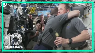 Russian cosmonaut, NASA astronaut hug during change of command ceremony on ISS