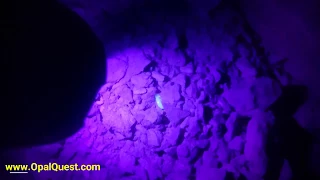 Opal in floor of mine using black light