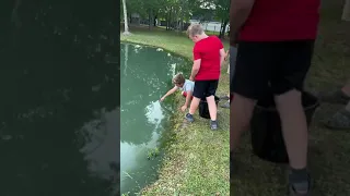 Kid catches fish using just his hands