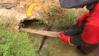 Unclogging Culvert Releasing Water Into The River