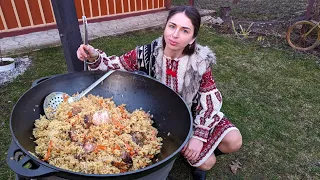 Woman is cooking TRADITIONAL Pilaf and chebureks in village. Crimean Tatar dishes with lamb
