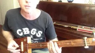How to play Folsom Prison Blues on a 3 string slide cigar box guitar by Nigel McTrustry