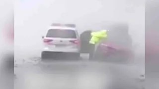 Police officer searches for stranded people amid downpour in central China