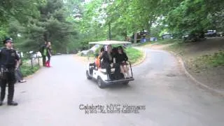 Jane Lynch waives to fans seated on a golf cart in Central Park