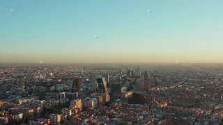 Backwards descending footage of large city in sunset time. Aerial panoramic view of town development