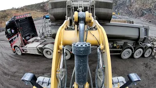 a day at work Caterpillar 972M XE wheel loaders loads truck and dumpers