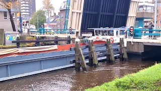 Ambulance met spoed wacht voor openstaande brug vanwege binnenvaartschip Alpha in Groningen.