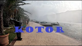 You are walking in Kotor, Montenegro, under heavy summer rain