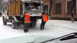 Garbage men slide on snow road