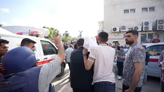 Relatives carry shrouded remains of victims killed in Israeli airstrike out of hospital morgue