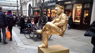 Levitating Gold Man London busker street performer, floating magic trick. Golden Man Covent Garden