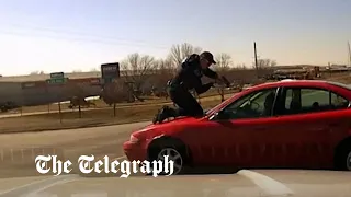 Police officer breaks back after clinging to car roof of suspect fleeing traffic stop