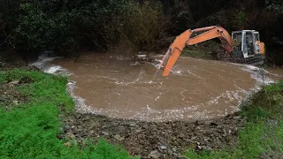 Digger clears blocked culvert to save road during 100 year Nelson Flood