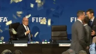 Comedian throws money at Blatter during press conference