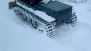 Самодельный гусеничный вездеход чистит снег.Homemade crawler all-terrain vehicle cleans snow.