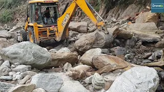 Backhoe Removing River Stone-Road Building for Cardamom Transportation