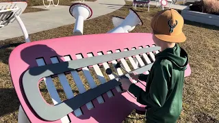 Lucas playing an outdoor xylophone