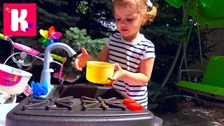 Katy plays in the garden with toys for girls