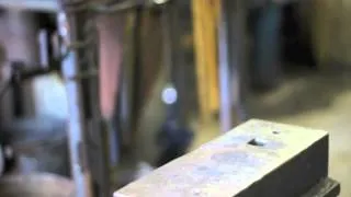 Forging a hammer eye punch with a striker.