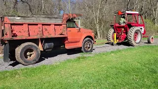 old chevrolet dump truck gets towed behind a tractor