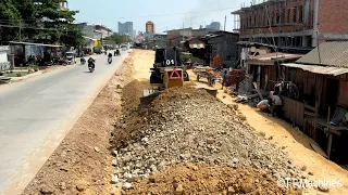 New Road Development Project By Strong Bulldozer Pushing Rock With Dump Trucks Unloading Rock