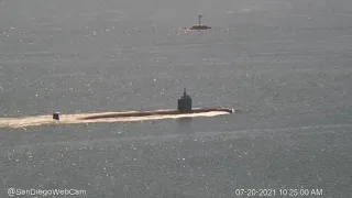 Dolphins playing off the bow of the outbound submarine USS Alexandria (SSN-757)