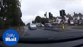 Driver speeds through red light on wrong side of the road - Daily Mail