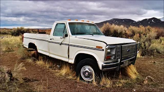 An abandoned pickup truck and a Log Cabin in the Desert