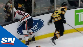 Glass Pops Out After Bruins’ Sean Kuraly Hits Oilers’ Matthew Benning Into Boards