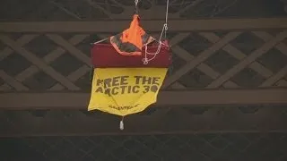 Greenpeace activist dangles from Eiffel Tower in Russian protest