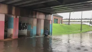 City worker clearing drains under Marconi Drive during Flash Flood Warning