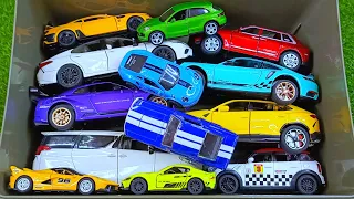 Box full of various miniature cars Peugeot, Volvo, Renault, Hyundai, Pagani, Cadillac One, DHL 52