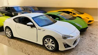 Big Diecast Model Cars Moving by Hand On Windowsill