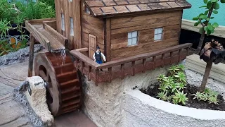 Sorprendente jardin miniatura con rueda de molino, cascada, estanque y jardinera para suculentas.