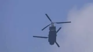 Chinook with Man on tail door hovering over the house