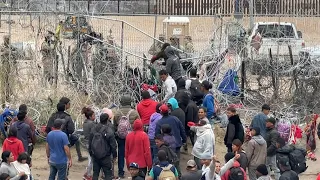 Migrants attempt to pull down section of wire fence on Mexico-US border | AFP