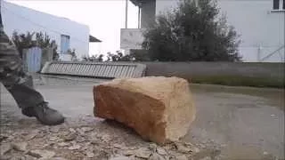 Split up a large stone with a sledgehammer.