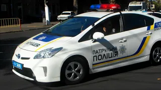 Police cars with sirens and PA close intersections for passage of the column