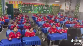 Chinese school children exercising at their desks.