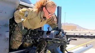 She is holding a powerful GAU-18A machine gun. US Air Force HH-60 Pave Hawk helicopter.