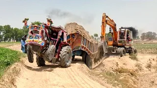 massey tractor stuck in mud with heavy loaded trolley rescued by excavator tractor | tractor