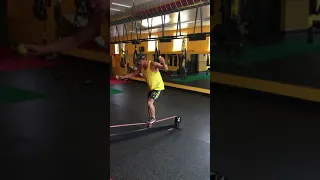 Single leg balance on slack line with ball toss.