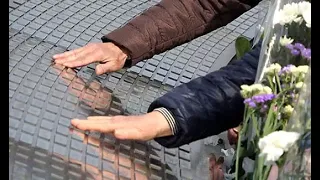 慰霊碑に花を手向ける人々