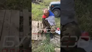 Ukrainian soldiers help a wounded Russian prisoner who surrendered near Kupyansk today