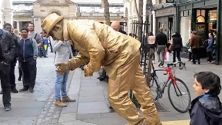 Golden man London street performer, floating and levitating trick Covent Gardens