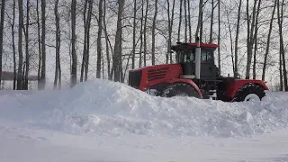 Кировец с передним отвалом против снега