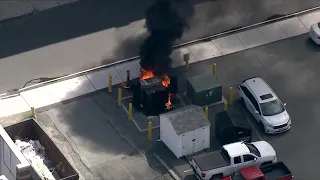 Heavy flames, black smoke erupt from transformer on city street