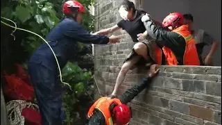 Firefighter uses his back as bridge for trapped villagers in flood