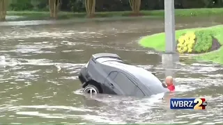 Firefighters save driver after car swept away in flash floods