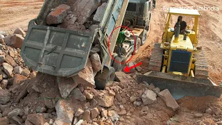 Be careful when dump truck unloading stone and Bulldozer working push stone back fill on the forest